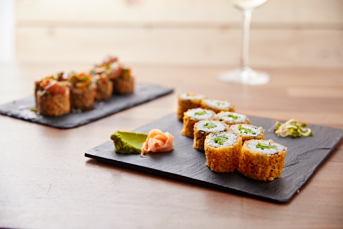 Pieces of crispy California sushi served with an blurry glass of wine