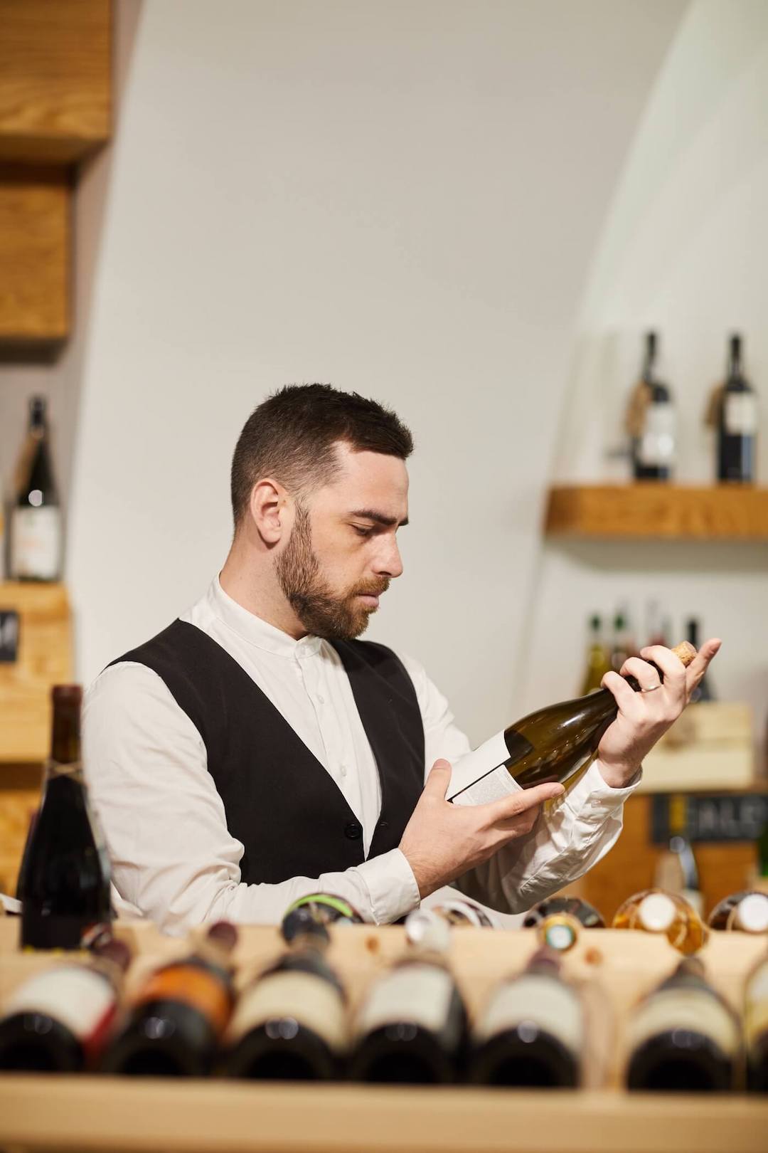 Un sommelier professionnel choisissant un vin en cave