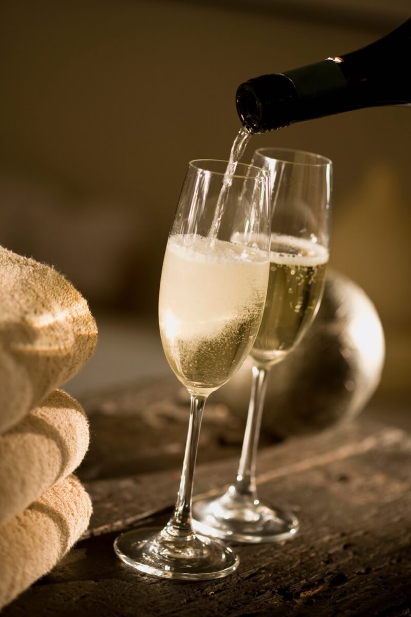 2 glasses of sparkling wine on a wooden table