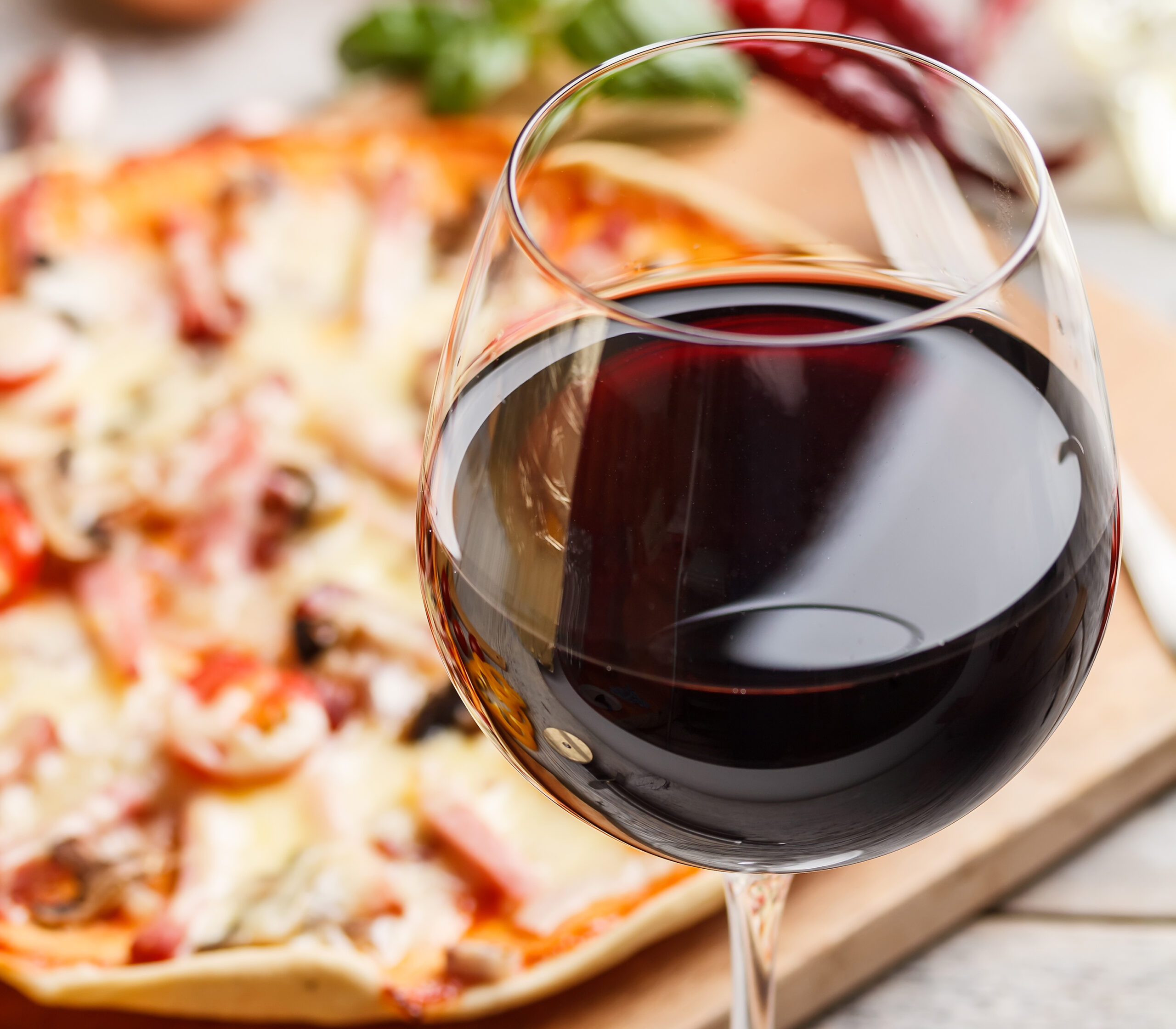 View of a glass of red wine with pizza